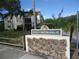 Patrician Oaks condo building sign surrounded by lush landscaping and tropical palm trees at 860 Virginia St # 308, Dunedin, FL 34698