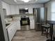 Modern kitchen features stainless steel appliances, white cabinetry, and stylish backsplash at 860 Virginia St # 308, Dunedin, FL 34698