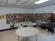 A communal library provides quiet reading and study space, full of books and tables at 860 Virginia St # 308, Dunedin, FL 34698