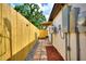 Side yard featuring a privacy fence, brick pathway, outdoor seating, and the home's exterior at 4210 E Grove St, Tampa, FL 33610