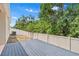 Fenced-in backyard with wood deck and view of trees, providing privacy at 10563 Laguna Plains Dr, Riverview, FL 33578
