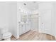 Bright bathroom featuring wood-look floors, dual vanity, and glass-enclosed shower at 10563 Laguna Plains Dr, Riverview, FL 33578