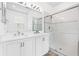Bathroom with a double sink vanity with storage below and glass shower at 10563 Laguna Plains Dr, Riverview, FL 33578