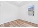 Bright bedroom featuring wood-look floors and a window at 10563 Laguna Plains Dr, Riverview, FL 33578