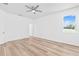 Bright bedroom with wood floors, ceiling fan, and a window with a peaceful view at 10563 Laguna Plains Dr, Riverview, FL 33578