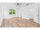 Spacious bedroom with wood floors, a ceiling fan, and a large window at 10563 Laguna Plains Dr, Riverview, FL 33578