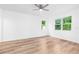 Bright bedroom with wood floors, a ceiling fan, and natural light from two windows at 10563 Laguna Plains Dr, Riverview, FL 33578
