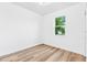 Cozy bedroom features white walls, wood-look floors, and a bright window at 10563 Laguna Plains Dr, Riverview, FL 33578