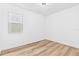Bright, clean bedroom featuring wood-look floors and a well-lit window at 10563 Laguna Plains Dr, Riverview, FL 33578