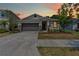 Charming single-story home featuring a well-manicured lawn and stone veneer accents at 10563 Laguna Plains Dr, Riverview, FL 33578
