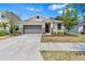 Charming single-story home featuring a well-manicured lawn and stone veneer accents at 10563 Laguna Plains Dr, Riverview, FL 33578