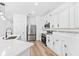 Modern kitchen featuring white cabinets, stainless steel appliances, and island with seating at 10563 Laguna Plains Dr, Riverview, FL 33578