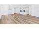 Bright living room with wood floors, modern lighting, and seamless flow to other rooms at 10563 Laguna Plains Dr, Riverview, FL 33578