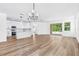 Open concept living room and kitchen with wood floors, white cabinets, and natural light at 10563 Laguna Plains Dr, Riverview, FL 33578