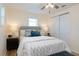 Comfortable bedroom featuring a queen bed, bedside tables, a decorative bench, and natural light from two windows at 1114 Michigan N Dr, Dunedin, FL 34698