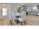 Bright dining area with round table, seating for four, and stainless steel refrigerator and gray cabinetry in the background at 1114 Michigan N Dr, Dunedin, FL 34698