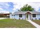 Light blue home showing off driveway carport and landscaping, creating an inviting curb appeal at 1114 Michigan N Dr, Dunedin, FL 34698