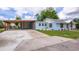View of the exterior of a charming home highlighting the carport and inviting front lawn at 1114 Michigan N Dr, Dunedin, FL 34698