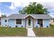 Front exterior view of a light blue home showcasing fresh landscaping, newer roof and charming curb appeal at 1114 Michigan N Dr, Dunedin, FL 34698