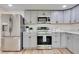 Stylish kitchen featuring stainless steel appliances, gray cabinetry, modern countertops, and wood-look floors at 1114 Michigan N Dr, Dunedin, FL 34698
