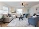 Bright living room with cozy seating, neutral decor, ceiling fan, and wood-look flooring at 1114 Michigan N Dr, Dunedin, FL 34698