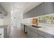 Galley kitchen featuring gray cabinets, ample counter space, a stainless steel sink, and bright light at 11301 88Th Ave, Seminole, FL 33772