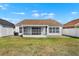 Backyard with screen porch and well-maintained lawn at 11307 Calgary Cir, Tampa, FL 33624
