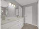 Bathroom featuring double sink vanity with white cabinets, tile floors, and a framed mirror at 11307 Calgary Cir, Tampa, FL 33624