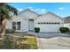Inviting single-Gathering home featuring a well-maintained lawn, bushes, and a two-car garage at 11307 Calgary Cir, Tampa, FL 33624