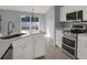 Updated kitchen features white cabinets, stainless appliances and a modern sink at 11307 Calgary Cir, Tampa, FL 33624