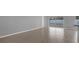 Spacious living area showcasing tile floors, sliding glass doors to patio, and neutral gray walls at 11307 Calgary Cir, Tampa, FL 33624