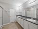 This bathroom features a double vanity with granite countertop, framed by tile flooring and complemented by a glass shower at 12607 Flatwood Creek Dr, Gibsonton, FL 33534