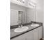 Bathroom features double sinks with granite countertops, large mirror, and white cabinets at 12607 Flatwood Creek Dr, Gibsonton, FL 33534