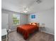 Bright bedroom features neutral walls, a ceiling fan, and a comfy bed next to a desk, perfect for relaxing at 12607 Flatwood Creek Dr, Gibsonton, FL 33534