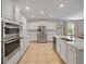 Modern kitchen with stainless steel appliances, white cabinetry, and a central island at 12607 Flatwood Creek Dr, Gibsonton, FL 33534