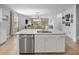 Bright kitchen island with stainless steel dishwasher and marble countertops overlooks the living and dining area at 12607 Flatwood Creek Dr, Gibsonton, FL 33534
