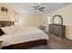 This primary bedroom features a large bed, ceiling fan, and light yellow walls, complemented by a vanity and wooden dresser at 12607 Flatwood Creek Dr, Gibsonton, FL 33534