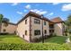 Two story condo building with brown trim, green grass, and well maintained landscaping at 12900 Vonn Rd # F101, Largo, FL 33774