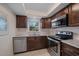 Updated kitchen with dark cabinets, stainless steel appliances, granite countertops, and a white tiled backsplash at 12900 Vonn Rd # F101, Largo, FL 33774