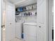 Laundry closet with newer washer and dryer units and wire shelving units for storage at 12900 Vonn Rd # F101, Largo, FL 33774