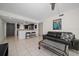 Inviting living room featuring tile flooring, a comfortable sofa, and an open layout to the kitchen at 12900 Vonn Rd # F101, Largo, FL 33774