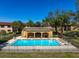 Community pool features a pavilion and lounge chairs for residents under a clear blue sky at 12900 Vonn Rd # F101, Largo, FL 33774