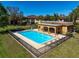 Community pool featuring an enclosed pool house, and surrounding lawn at 12900 Vonn Rd # F101, Largo, FL 33774