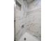Tiled shower featuring a shower head with marble-style tile and a built-in niche at 12900 Vonn Rd # F101, Largo, FL 33774