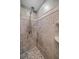 The stand up shower features neutral colored tiling, a built-in shelf and a river rock floor at 12900 Vonn Rd # F101, Largo, FL 33774