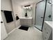 Modern bathroom with dual vanities, stylish mirrors, and a glass-enclosed shower with decorative tile at 12907 College Hill Dr, Hudson, FL 34667