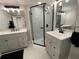 Modern bathroom with dual vanities, stylish mirrors, and a glass-enclosed shower with decorative tile at 12907 College Hill Dr, Hudson, FL 34667