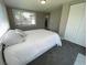 Comfortable bedroom featuring neutral gray walls, soft carpeting, a large window, and closet storage at 12907 College Hill Dr, Hudson, FL 34667