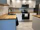 Updated kitchen with stainless steel appliances, butcher block countertops, and a subway tile backsplash at 12907 College Hill Dr, Hudson, FL 34667