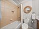 Cozy bathroom with tiled shower/bath and decorative round mirror above the toilet at 13209 Palmilla Cir, Dade City, FL 33525